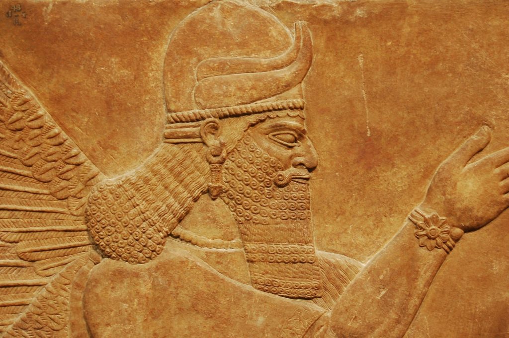 Detailed view of an ancient Assyrian relief sculpture showcasing intricate patterns in a museum in London.